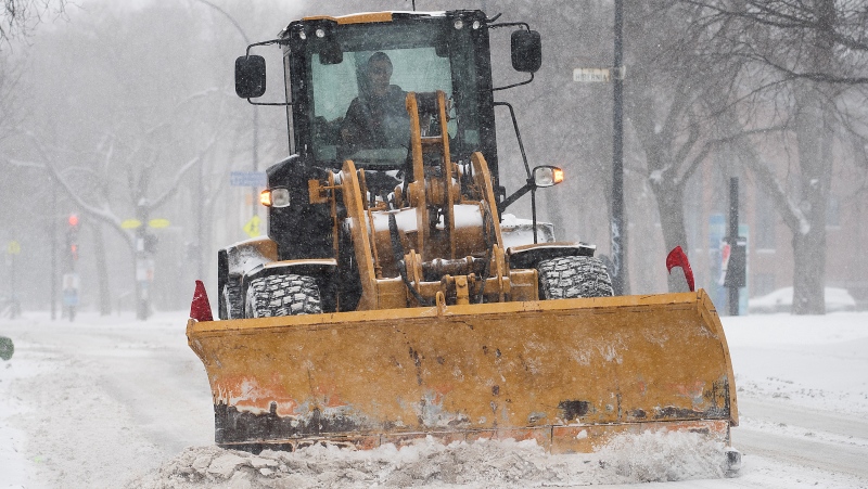 FILE: A plow clears a street during a snowstorm in Montrea. THE CANADIAN PRESS/Graham Hughes