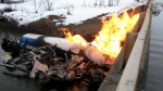 This image provided by Vermont State Police shows a propane tanker on fire in the Black River after it went off Vermont Route 14 in Irasburg, Vt., on Monday, Dec. 4, 2023. (Vermont Hazardous Materials Response Team via AP)