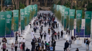 People walk through the COP28 UN Climate Summit, Monday, Dec. 4, 2023, in Dubai, United Arab Emirates. (AP Photo/Peter Dejong)