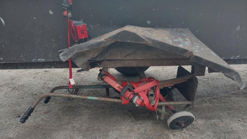 A rusted dolly is strapped to a trailer in place of a wheel. (Source: OPP)