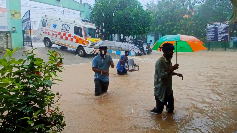 People walk outside the Tambaram Government Hospital flooded following heavy rains along the Bay of Bengal coast in Chennai, India, Monday, Dec.4, 2023.  (AP Photo)