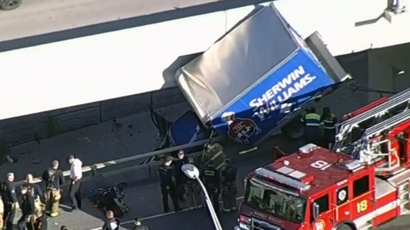 WATCH: Truck hangs from bridge after crash