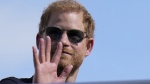 Prince Harry, The Duke of Sussex, waves during the Formula One U.S. Grand Prix auto race at Circuit of the Americas, Sunday, Oct. 22, 2023, in Austin, Texas. (AP Photo/Nick Didlick)