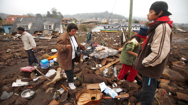 Residents search for belongings to recover from destroyed houses by the sea in Pelluhue, Chile, some 332 kilometres southwest Santiago, Sunday, Feb. 28, 2010. (AP / Roberto Candia)