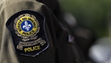 A Surete du Quebec emblem is seen on an officer’s uniform in Montreal on August 22, 2023. THE CANADIAN PRESS/Christinne Muschi