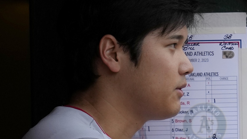Shohei Ohtani stands in the dugout during a baseball game against the Oakland Athletics in Oakland, Calif., Saturday, Sept. 2, 2023. (AP Photo/Jeff Chiu)