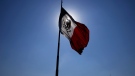 A Mexican flag waves in front of The National Palace, the office of the president, in Mexico City's main square, the Zocalo, at sunrise, April 24, 2023. (AP Photo/Marco Ugarte, File)