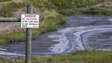 Tailings drain into a pond at the Syncrude oilsands mine facility near Fort McMurray, Alta., Wednesday, July 9, 2008. (THE CANADIAN PRESS/Jeff McIntosh)