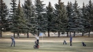 Golfers celebrate a nice putt on at temporary green at the Shaganappi Point golf course in Calgary, Tuesday, Dec. 5, 2023.  THE CANADIAN PRESS/Jeff McIntosh