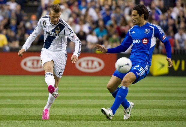 LA Galaxy's David Beckham kicks the ball away from Montreal Impact Corradi Bernardo during first half MLS soccer action in Montreal on Saturday, May 12, 2012. THE CANADIAN PRESS/Paul Chiasson