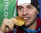 Moguls skier Alexandre Bilodeau -- who won the first of 14 Canadian gold medals -- bites that medal during a ceremony at the 2010 Winter Olympic Games in Vancouver on Monday, Feb. 15, 2010. (THE CANADIAN PRESS/Nathan Dennette)