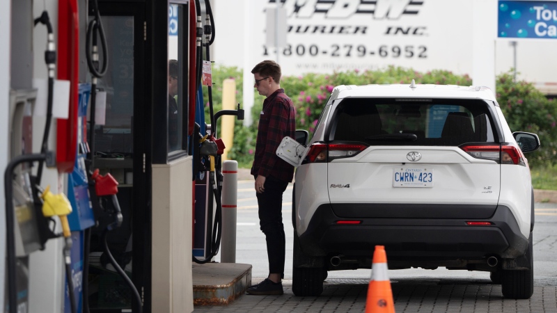 A motorist stands at the fuel pump to fill their tanks in Halifax, Friday, June 30, 2023. (THE CANADIAN PRESS/Darren Calabrese)