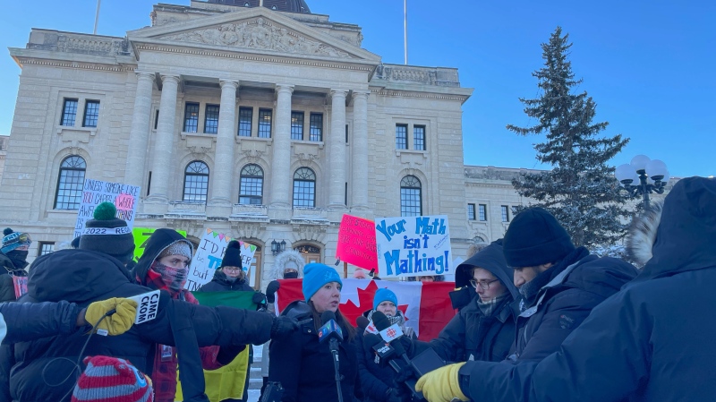 Saskatchewan Teachers' Federation president Samantha Becotte speaks to reporters in from of the Saskatchewan Legislative Building while teachers and supporters picket in the background. (Katy Syrota/CTV News)