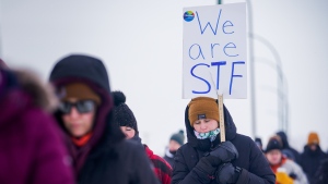 A person holds a sign while walking at a demonstration site during a province-wide, one-day strike organized by the members of Saskatchewan Teachers’ Federation in Saskatoon, Sask., on Monday, January 22, 2024. THE CANADIAN PRESS/Heywood Yu