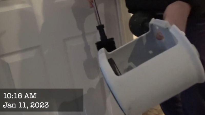 A search video of a fraud investigator discovering a phone in a toilet caddy at the house Colin Murphy was staying at in January 2023. 