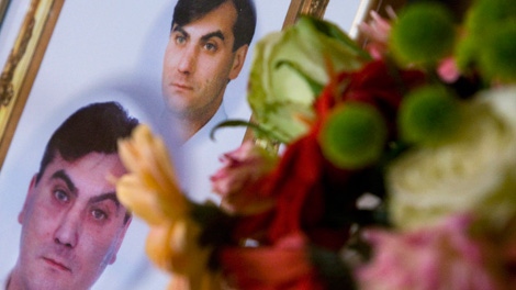 A picture of Robert Dziekanski lies next to a bouquet of flowers during a news conference in Vancouver. Oct. 25, 2007. (THE CANADIAN PRESS/Jonathan Hayward)
