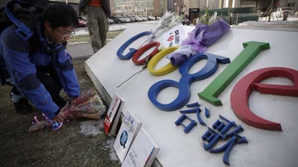 A Chinese Google user presents flowers in front of Google sign outside Google China headquarters in Beijing, Friday, Jan. 15, 2010. (AP / Vincent Thian)