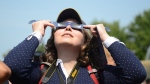 Canada's largest school board is voting Wednesday on whether it should revise its school calendar so students can stay home on the day a rare solar eclipse will partially and, for a fleeting few minutes in some areas, totally dim daylight. Observers watch a solar eclipse at the Canadian National Exhibition in Toronto on Monday, August 21, 2017. THE CANADIAN PRESS/Jon Blacker
