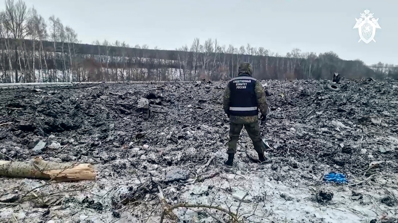 In this photo taken from video released by Russian Investigative Committee on Thursday, Jan. 25, 2024, an investigator walks in a field where a Russian military transport crashed a day earlier near Yablonovo, in the Belgorod region of Russia. (Russian Investigative Committee via AP, File)