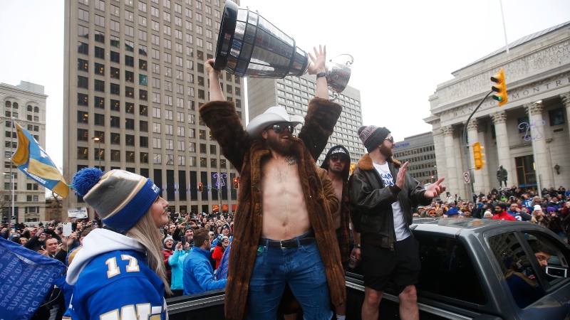 Winnipeggers crowd the downtown streets Tuesday, Nov. 26, 2019, to celebrate with quarterback Chris Streveler, centre, as he raises the cup with other players the end of a Grey Cup drought that lasted almost three decades. The Bombers have resigned Streveler to a one-year deal to return to the team following a stint in the NFL. THE CANADIAN PRESS/John Woods
