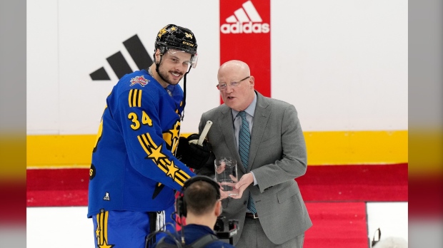 Joe Daly, right, presents NHL All-Star Team Matthews Captain, forward Auston Matthews (34), of the Toronto Maple Leafs, with the trophy for Most Valuable Player after Team Matthews' victory at the NHL All-Star Game, in Toronto, Saturday, Feb. 3, 2024. THE CANADIAN PRESS/Nathan Denette