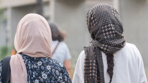 Women wear hijabs as they walk along a street in Montreal, Thursday, August 11, 2022. THE CANADIAN PRESS/Graham Hughes