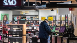 A man purchases alcohol at a SAQ outlet in Montreal, Tuesday, January 18, 2022. THE CANADIAN PRESS/Graham Hughes