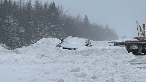 Plows and tow trucks rescue a car stuck in snow along Highway 125 in Sydney, N.S. (Source: Ryan MacDonald/CTV News Atlantic)