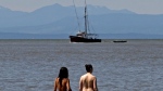People walk in the water after taking part in a world record skinny-dip attempt at Wreck Beach in Vancouver, B.C., on July 10, 2010. (THE CANADIAN PRESS/Darryl Dyck)