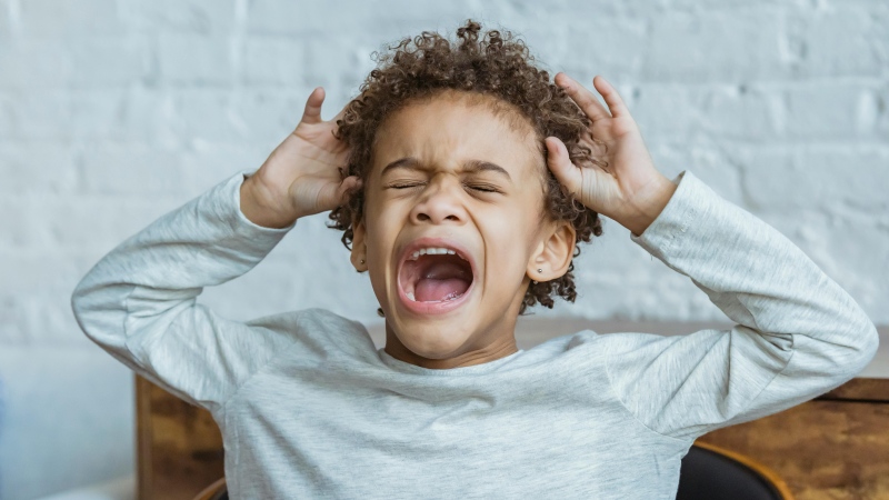A child reacts to having a headache. (Credit: Keira Burton/pexels.com)