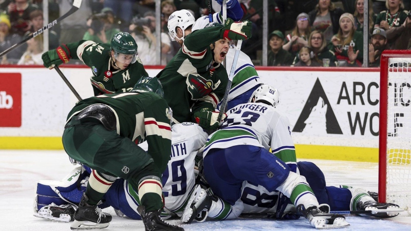 Minnesota Wild centre Joel Eriksson Ek, middle, reacts as members of the Vancouver Canucks and Minnesota Wild compete for the puck in front of the net during the third period of an NHL hockey game, Monday, Feb. 19, 2024, in St. Paul, Minn. (AP Photo/Matt Krohn)