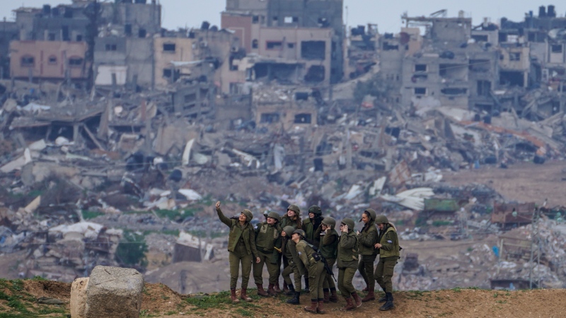 Israeli female soldiers pose for a photo on a position on the Gaza Strip border, in southern Israel, Monday, Feb. 19, 2024. (AP Photo/Tsafrir Abayov) 