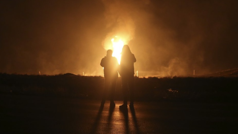Two men look at flames after a natural gas pipeline explodes outside the city of Boroujen in the western Chaharmahal and Bakhtiari province, Iran, in early Wednesday, Feb. 14, 2024. (Reza Kamali Dehkordi/Fars News Agency via AP)