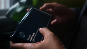 A person holds a smartphone set to the opening screen of the ArriveCan app in a photo illustration made in Toronto on June 29, 2022. THE CANADIAN PRESS/Giordano Ciampini