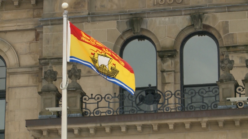 The New Brunswick flag waves in front of the New Brunswick legislature. (CTV/Laura Brown)