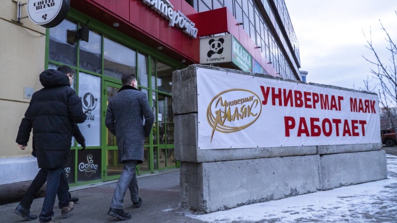 Men walk past a shelter at a food shop in Belgorod, Russia, on Monday, Feb. 19, 2024. Belgorod has come under repeated Ukrainian shelling, and hundreds of bus stops in the city near the border with Ukraine have been reinforced with blocks of concrete and sandbags to protect them from rocket strikes. (AP Photo/Kirill Zarubin)