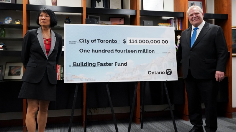 Toronto Mayor Olivia Chow, left, and Ontario Premier Doug Ford, right, pose for a photo with a cheque to the City of Toronto for housing development at Toronto City Hall, in Toronto on Thursday, Feb. 22, 2024. (THE CANADIAN PRESS/Arlyn McAdorey )