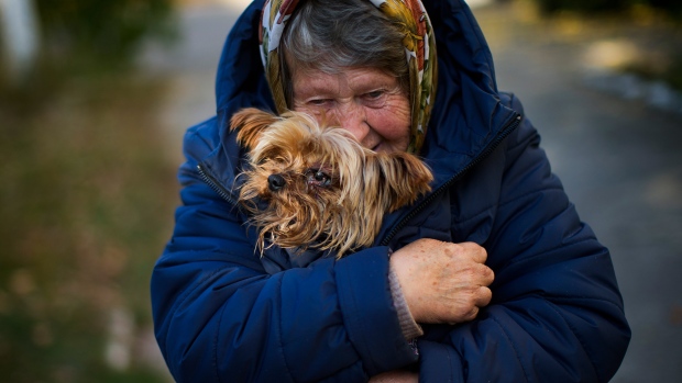 A woman warms her dog in Kivsharivka, Ukraine, Sunday, Oct. 16, 2022.  (AP Photo / Francisco Seco)