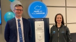 Hope Air chief development officer, Jon Collins, stands in front of a Hope Air pay station with Greater Moncton Romeo LeBlanc International Airport president and CEO, Courtney Burns. (CTV/Alana Pickrell)