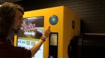 Fourth-year University of Waterloo student River Stanley explains where students have been trying to cover a hole on a vending machine that they believe houses a camera. (Colton Wiens/CTV Kitchener)