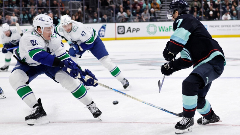 Vancouver Canucks centre Dakota Joshua, left, defends during the third period of an NHL hockey game, Thursday, Feb. 22, 2024, in Seattle. (AP Photo/John Froschauer)