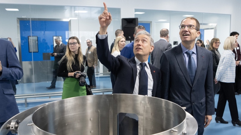 Moderna chief executive Stephane Bancel, right, and Federal Industry Minister Francois-Philippe Champagne, left, tour the company's soon-to-open vaccine production facility in Laval, Que., Friday, Feb. 23, 2024. (Ryan Remiorz/The Canadian Press)