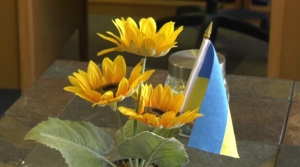 A Ukrainian flag sits in a pot with sunflowers on a desk in Winnipeg on Feb. 23, 2024. (Alexandra Holyk/CTV News Winnipeg)