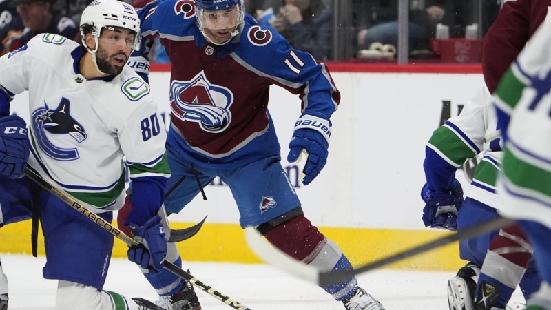 Vancouver Canucks left wing Arshdeep Bains, left, jostles for position with Colorado Avalanche centre Andrew Cogliano in the first period of an NHL hockey game Tuesday, Feb. 20, 2024, in Denver. THE CANADIAN PRESS/AP-David Zalubowski