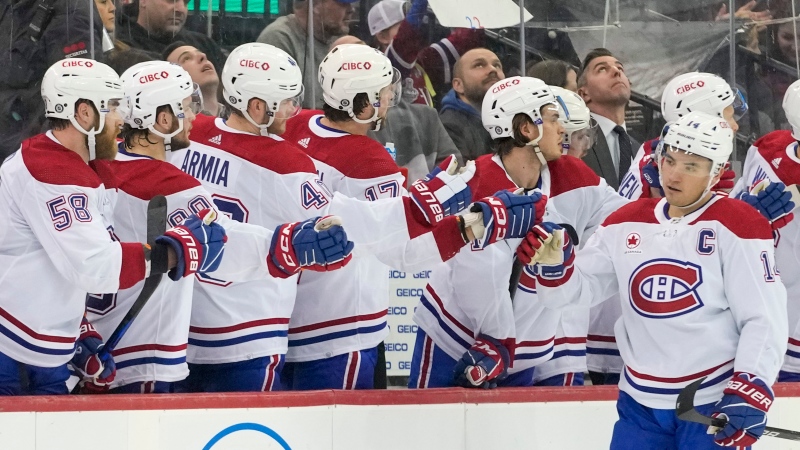 Montreal Canadiens center Nick Suzuki (14) celebrates with teammates after scoring against the New Jersey Devils during the second period of an NHL hockey game, Saturday, Feb. 24, 2024, in Newark, N.J. (Mary Altaffer, The Associated Press)
