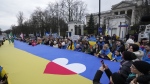 Ukrainians and Poles march with a giant Ukrainian flag in protest of Russia's military aggression against Ukraine on the second anniversary of the war, in front of the Russian Embassy in Warsaw, Poland, Saturday Feb. 24, 2024. (AP Photo/Czarek Sokolowski)