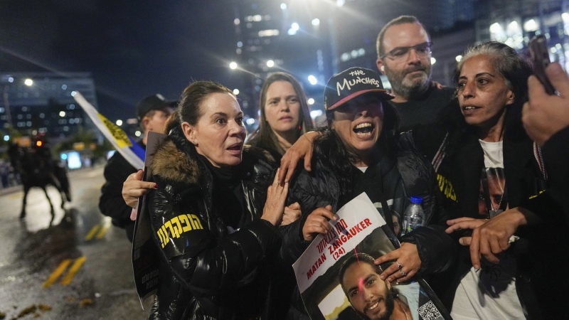 Former hostage Ilana Grisewsky, center, takes part in a protest calling on Israel's government to return the remaining abductees held by Hamas in Gaza on Saturday, Feb. 22, 2024. The protesters merged with anti-government demonstrators, prompting police to use water cannons to disperse the crowds. (AP Photo/Ohad Zwigenberg)