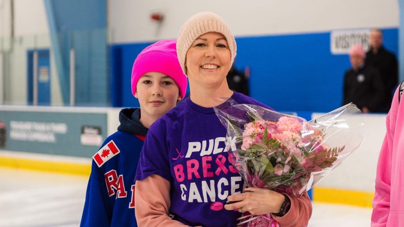 Sarah Cochrane holds a bouquet of flowers as the U14 Kitchener AAA hockey team hosts a tournament in support of cancer research. Feb. 25, 2024 (Hannah Schmidt / CTV News)