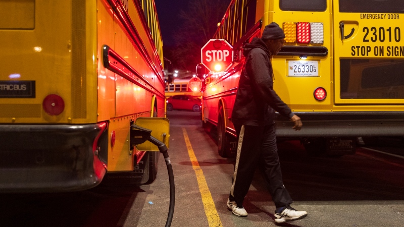 A electric school bus driver examines his safety stop signs before driving to school inside the Montgomery County Schools bus lot, Friday, Feb. 9, 2024, in Rockville, Md. (AP Photo/Tom Brenner)