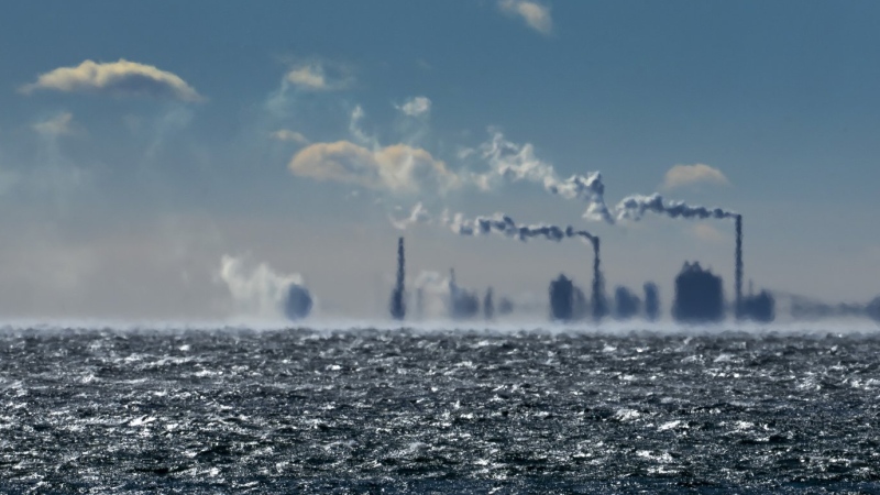 Smokestacks in the distance shimmer in the cold waves over Lake Ontario in Toronto, Friday, Feb. 3, 2023. THE CANADIAN PRESS/Frank Gunn